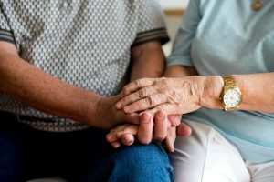 Two senior holding hands