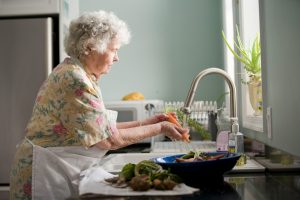 An old woman washing vegetables