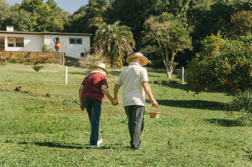 A couple of people walking on the grass